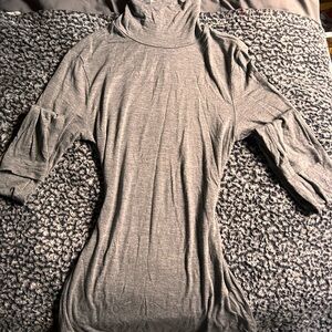 Grey turtleneck with high neck, made from a soft and stretchy material.